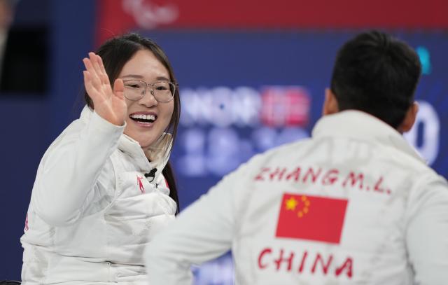 (260310) -- CORTINA D'AMPEZZO, March 10, 2026 (Xinhua) -- Li Nana (L) of China celebrates with teammate Zhang Mingliang during the wheelchair curling mixed team round robin session 6 match between China and Norway at the Milan-Cortina 2026 Paralympic Winter Games in Cortina D'ampezzo, Italy, March 9, 2026. (Xinhua/Wang Kaiyan)