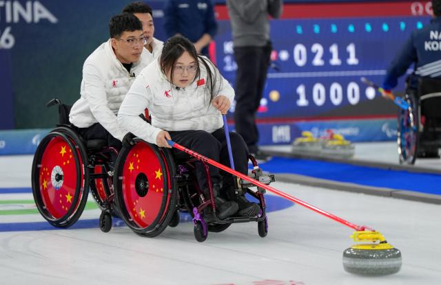 (260310) -- CORTINA D'AMPEZZO, March 10, 2026 (Xinhua) -- Li Nana (R) of China competes during the wheelchair curling mixed team round robin session 6 match between China and Norway at the Milan-Cortina 2026 Paralympic Winter Games in Cortina D'ampezzo, Italy, March 9, 2026. (Xinhua/Wang Kaiyan)