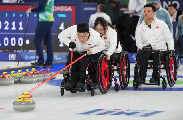 (260310) -- CORTINA D'AMPEZZO, March 10, 2026 (Xinhua) -- Chen Jianxin (L) of China competes during the wheelchair curling mixed team round robin session 6 match between China and Norway at the Milan-Cortina 2026 Paralympic Winter Games in Cortina D'ampezzo, Italy, March 9, 2026. (Xinhua/Wang Kaiyan)