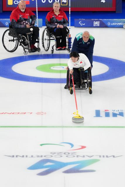 (260310) -- CORTINA D'AMPEZZO, March 10, 2026 (Xinhua) -- Wang Meng (front) of China competes during the wheelchair curling mixed doubles round robin session 7 between China and the United States at the Milan-Cortina 2026 Paralympic Winter Games in Cortina D'ampezzo, Italy, March 9, 2026. (Xinhua/Lian Yi)