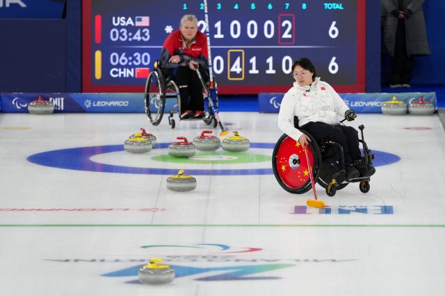 (260310) -- CORTINA D'AMPEZZO, March 10, 2026 (Xinhua) -- Wang Meng (R) of China competes during the wheelchair curling mixed doubles round robin session 7 between China and the United States at the Milan-Cortina 2026 Paralympic Winter Games in Cortina D'ampezzo, Italy, March 9, 2026. (Xinhua/Lian Yi)
