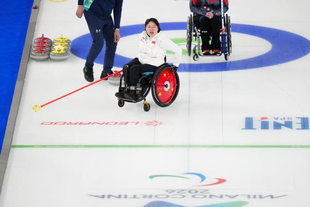 (260310) -- CORTINA D'AMPEZZO, March 10, 2026 (Xinhua) -- Wang Meng (C) of China reacts during the wheelchair curling mixed doubles round robin session 7 between China and the United States at the Milan-Cortina 2026 Paralympic Winter Games in Cortina D'ampezzo, Italy, March 9, 2026. (Xinhua/Lian Yi)