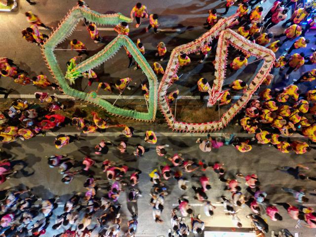 (260310) -- BEIJING, March 10, 2026 (Xinhua) -- A drone photo shows people watching dragon dance during a traditional temple procession in Johor Bahru, Malaysia, March 9, 2026. The temple procession is a century-old folk event held here annually. (Xinhua/Chen Zeguo)