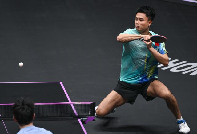 (260310) -- CHONGQING, March 10, 2026 (Xinhua) -- Zhou Qihao of China hits a return during the men's singles round of 32 match against Huang Youzheng of China at the WTT Champions Chongqing 2026 in southwest China's Chongqing, March 10, 2026. (Xinhua/Chen Cheng)