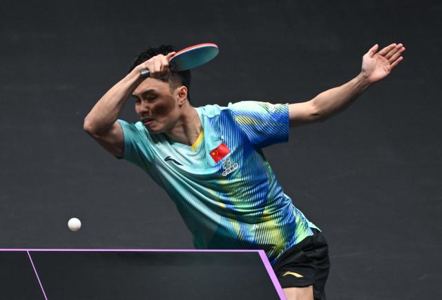 (260310) -- CHONGQING, March 10, 2026 (Xinhua) -- Zhou Qihao of China hits a return during the men's singles round of 32 match against Huang Youzheng of China at the WTT Champions Chongqing 2026 in southwest China's Chongqing, March 10, 2026. (Xinhua/Chen Cheng)