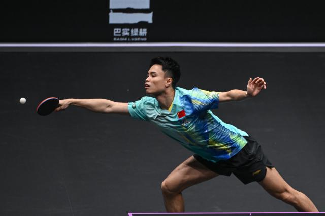 (260310) -- CHONGQING, March 10, 2026 (Xinhua) -- Zhou Qihao of China hits a return during the men's singles round of 32 match against Huang Youzheng of China at the WTT Champions Chongqing 2026 in southwest China's Chongqing, March 10, 2026. (Xinhua/Chen Cheng)