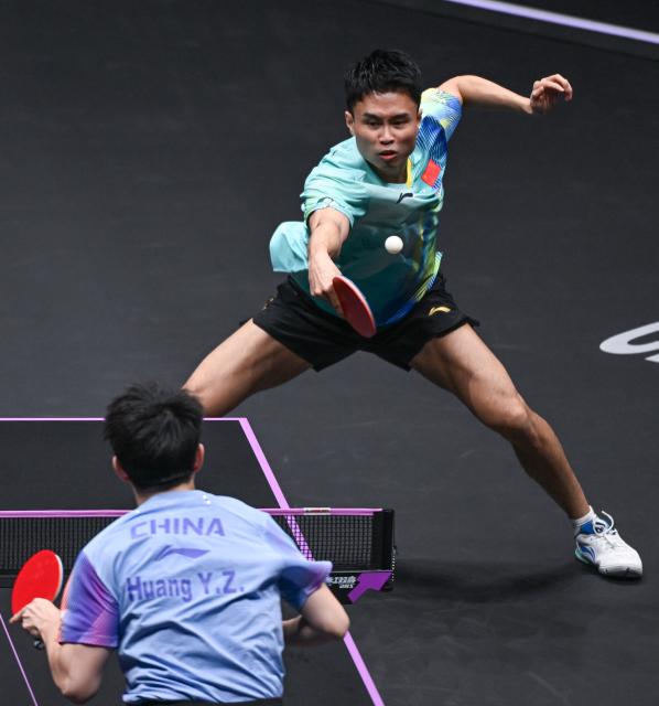 (260310) -- CHONGQING, March 10, 2026 (Xinhua) -- Zhou Qihao of China hits a return during the men's singles round of 32 match against Huang Youzheng of China at the WTT Champions Chongqing 2026 in southwest China's Chongqing, March 10, 2026. (Xinhua/Chen Cheng)