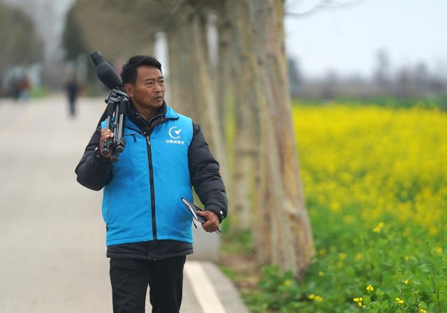 (260310) -- YUGAN, March 10, 2026 (Xinhua) -- Jiang Liangqing patrols a field visited by migratory birds in Yugan County, east China's Jiangxi Province, on Feb. 27, 2026. Poyang Lake, China's largest freshwater lake and an extensive wetland, is a vital wintering and stopover site along the East Asian-Australasian Flyway. Every winter, thousands of Siberian cranes, a critically endangered species, gather in Yugan County, which lies to the southeast of the lake. 
   Decades ago, local villagers faced a dilemma. On the one hand, capturing or killing migratory birds was against the law. On the other hand, leaving the birds undisturbed could lead to serious crop losses. To reduce the damage, villagers around the lake often went to great lengths to drive birds away, using firecrackers, beating gongs, and setting up scarecrows.
   To address the problem, local authorities introduced a compensation mechanism. Villagers whose crops have been damaged in the course of wetland and migratory bird conservation can receive compensation. The policy has helped reduce crop losses for villagers while supporting bird conservation. As a result, more migratory birds now winter at Poyang Lake, and the local birdwatching economy has flourished.
   Jiang Liangqing, once troubled by the "bird dilemma," is now a bird guardian in Yugan County. "I have more than 100 mu (about 6.67 hectares) of rice fields, where migratory birds often come to forage," Jiang said. "It used to be a problem, but now I receive compensation after local authorities assess my crop losses."
   "Now I'm a bird guardian. I patrol the wetlands every day and share knowledge about bird conservation with tourists," Jiang said. Like him, many local villagers have joined conservation efforts, including raising ecological awareness and patrolling wetlands. (Xinhua/Wan Xiang)