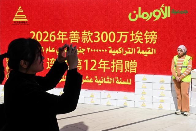 (260310) -- GIZA, March 10, 2026 (Xinhua) -- A woman poses for photos during a donation event in Giza, Egypt, March 9, 2026. The Chinese Chamber of Commerce in Egypt and the Egyptian Orman Association jointly held a donation event in Giza governorate on Monday to help Egyptian families in need.
   TO GO WITH "Chinese companies hold charity event in Egypt" (Xinhua/Xin Mengchen)