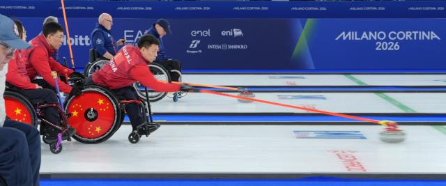 (260310) -- CORTINA D'AMPEZZO, March 10, 2026 (Xinhua) -- Zhang Mingliang (2nd R) of China competes during the wheelchair curling mixed team round robin session 7 match between China and Canada at the Milan-Cortina 2026 Paralympic Winter Games in Cortina D'ampezzo, Italy, March 10, 2026. (Xinhua/Cai Yang)
