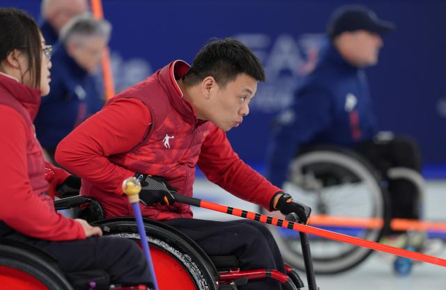(260310) -- CORTINA D'AMPEZZO, March 10, 2026 (Xinhua) -- Zhang Mingliang (R) of China competes during the wheelchair curling mixed team round robin session 7 match between China and Canada at the Milan-Cortina 2026 Paralympic Winter Games in Cortina D'ampezzo, Italy, March 10, 2026. (Xinhua/Cai Yang)