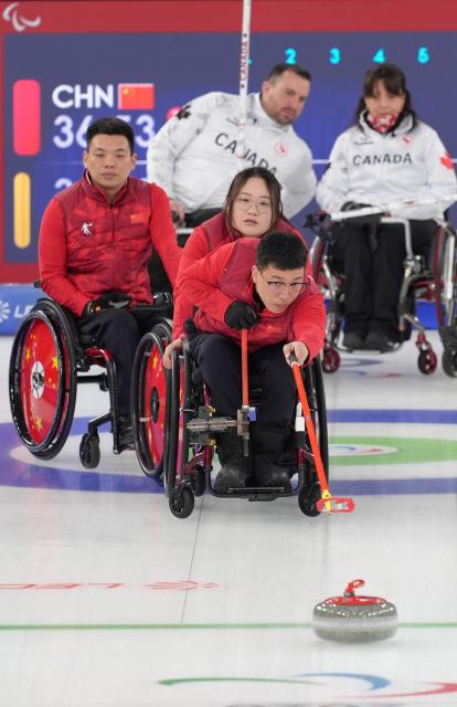 (260310) -- CORTINA D'AMPEZZO, March 10, 2026 (Xinhua) -- Chen Jianxin (front) of China competes during the wheelchair curling mixed team round robin session 7 match between China and Canada at the Milan-Cortina 2026 Paralympic Winter Games in Cortina D'ampezzo, Italy, March 10, 2026. (Xinhua/Cai Yang)