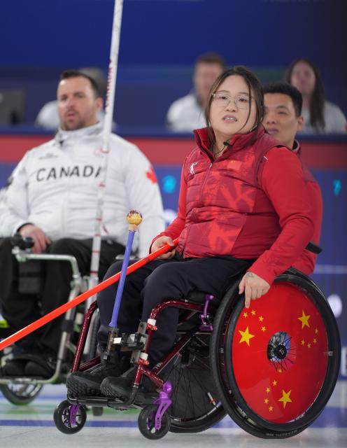 (260310) -- CORTINA D'AMPEZZO, March 10, 2026 (Xinhua) -- Li Nana (front R) of China reacts during the wheelchair curling mixed team round robin session 7 match between China and Canada at the Milan-Cortina 2026 Paralympic Winter Games in Cortina D'ampezzo, Italy, March 10, 2026. (Xinhua/Cai Yang)
