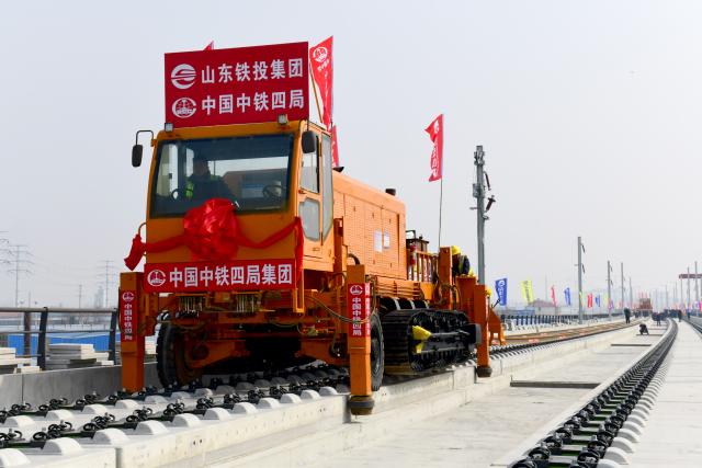 (260310) -- BINZHOU, March 10, 2026 (Xinhua) -- Staff members lay tracks at Binzhou railway station of the Jinan-Binzhou high-speed railway in Binzhou City, east China's Shandong Province, on March 10, 2026. The high-speed railway, which links the province's cities of Jinan and Binzhou and with a designed speed of 350 km/h, has officially entered the full-line track-laying operation phase on Tuesday. (Xinhua/Guo Xulei)