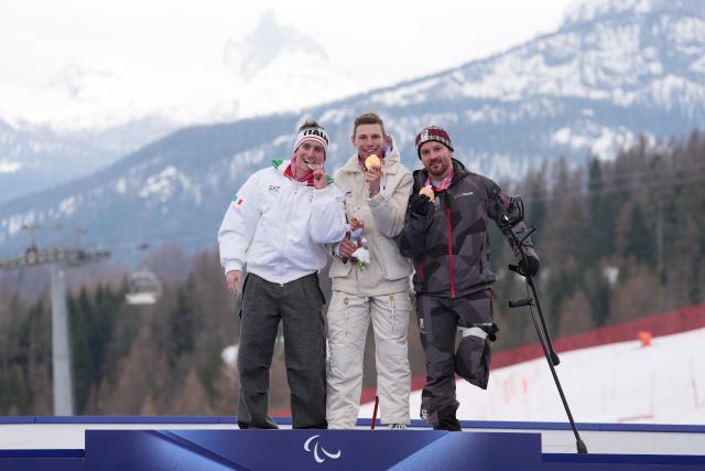 (260311) -- CORTINA D'AMPEZZO, March 11, 2026 (Xinhua) -- Gold medalist Arthur Bauchet (C) of France, silver medalist Federico Pelizzari (L) of Italy and bronze medalist Thomas Grochar of Austria pose on the podium during the awarding ceremony for the Para Alpine Skiing Men's Alpine Combined Standing event at the Milan-Cortina 2026 Paralympic Winter Games in Cortina D'ampezzo, Italy, March 10, 2026. (Xinhua/Lian Yi)