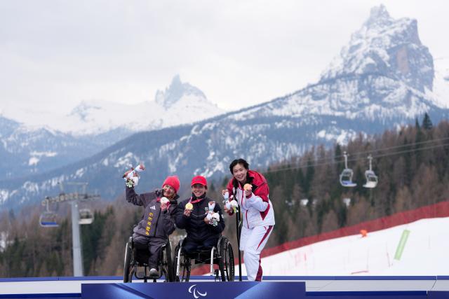 (260311) -- CORTINA D'AMPEZZO, March 11, 2026 (Xinhua) -- Gold medalist Audrey Pascual Seco (C) of Spain, silver medalist Anna-Lena Forster (L) of Germany, and bronze medalist Liu Sitong of China pose on the podium during the awarding ceremony for the para alpine skiing women's combined sitting event at the Milan-Cortina 2026 Paralympic Winter Games in Cortina D'ampezzo, Italy, March 10, 2026. (Xinhua/Lian Yi)