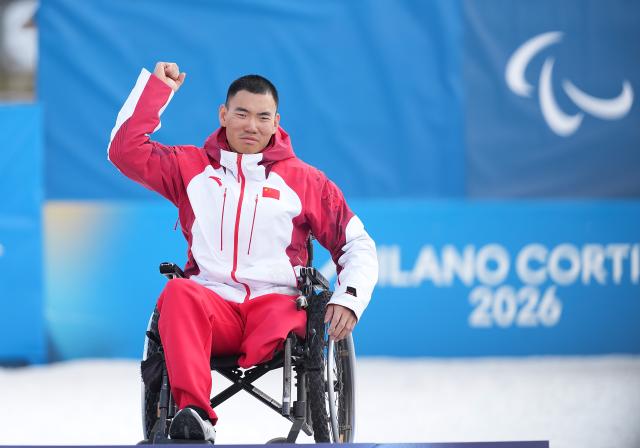 (260311) -- TESERO, March 11, 2026 (Xinhua) -- Gold medalist Liu Zixu of China poses on the podium after the final of the Para Cross-Country Skiing men's Sprint Sitting event at the Milan-Cortina 2026 Paralympic Winter Games in Tesero, Italy, March 10, 2026. (Xinhua/Hou Zhaokang)