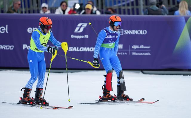 (260311) -- CORTINA D'AMPEZZO, March 11, 2026 (Xinhua) -- Giacomo Bertagnolli (R) and his guide Andrea Ravelli of Italy react after winning the Para Alpine Skiing Men's Alpine Combined Vision Impaired event at the Milan-Cortina 2026 Paralympic Winter Games in Cortina D'ampezzo, Italy, March 10, 2026. (Xinhua/Wang Kaiyan)