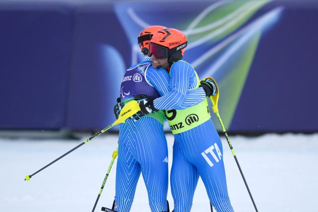 (260311) -- CORTINA D'AMPEZZO, March 11, 2026 (Xinhua) -- Giacomo Bertagnolli (L) hugs his guide Andrea Ravelli of Italy after winning the Para Alpine Skiing Men's Alpine Combined Vision Impaired event at the Milan-Cortina 2026 Paralympic Winter Games in Cortina D'ampezzo, Italy, March 10, 2026. (Xinhua/Lian Yi)