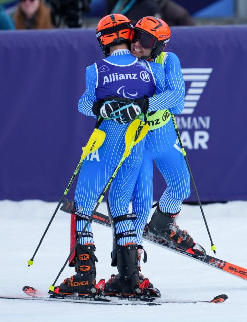 (260311) -- CORTINA D'AMPEZZO, March 11, 2026 (Xinhua) -- Giacomo Bertagnolli (L) and his guide Andrea Ravelli of Italy celebrate after winning the Para Alpine Skiing Men's Alpine Combined Vision Impaired event at the Milan-Cortina 2026 Paralympic Winter Games in Cortina D'ampezzo, Italy, March 10, 2026. (Xinhua/Wang Kaiyan)