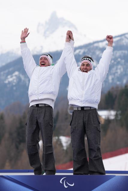 (260311) -- CORTINA D'AMPEZZO, March 11, 2026 (Xinhua) -- Gold medalist Giacomo Bertagnolli (L) and his guide Andrea Ravelli of Italy celebrate during the awarding ceremony for the Para Alpine Skiing Men's Alpine Combined Vision Impaired event at the Milan-Cortina 2026 Paralympic Winter Games in Cortina D'ampezzo, Italy, March 10, 2026. (Xinhua/Lian Yi)