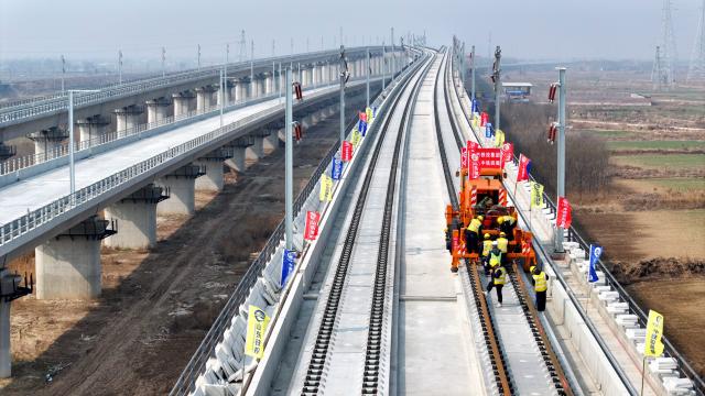 (260311) -- BEIJING, March 11, 2026 (Xinhua) -- An aerial drone photo shows staff members laying tracks at Binzhou railway station of the Jinan-Binzhou high-speed railway in Binzhou City, east China's Shandong Province, on March 10, 2026. The high-speed railway, which links the province's cities of Jinan and Binzhou and with a designed speed of 350 km/h, has officially entered the full-line track-laying operation phase on Tuesday. (Xinhua/Guo Xulei)