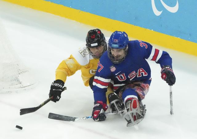 (260311) -- MILAN, March 11, 2026 (Xinhua) -- Che Hang (L) of China vies with David Eustace of the United States during the Para Ice Hockey preliminary round match of Group A between the United States and China at the Milan-Cortina 2026 Paralympic Winter Games in Milan, Italy, March 10, 2026. (Xinhua/Hou Jun)