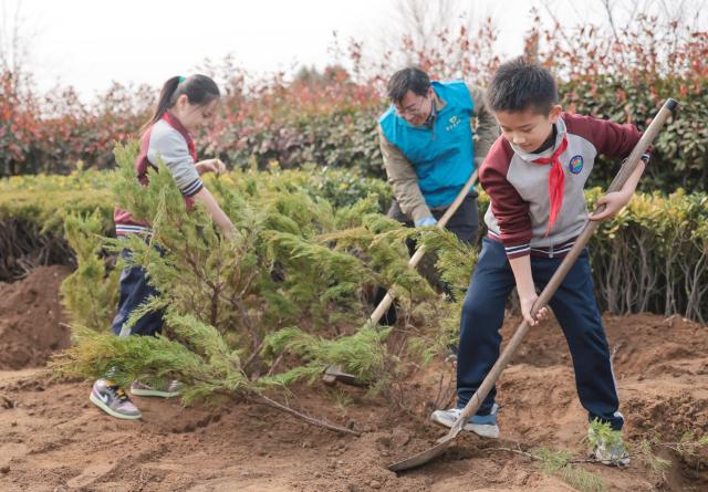 (260311) -- BEIJING, March 11, 2026 (Xinhua) -- Volunteers and students take part in a tree planting event in Rongcheng City, east China's Shandong Province, March 11, 2026. China designated March 12 as National Tree Planting Day in 1979, and launched a nationwide voluntary tree-planting campaign in 1981. With the 2026 National Tree Planting Day just around the corner, tree planting activities are held across the country to encourage more people to participate in afforestation work. (Photo by Li Xinjun/Xinhua)