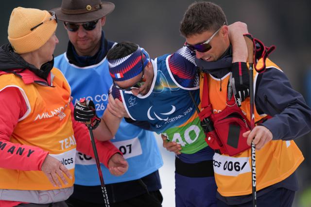 (260311) -- TESERO, March 11, 2026 (Xinhua) -- Karl Tabouret (2nd R) of France is helped up after winning the final match of the men's 10km interval start classic standing of Para Cross-Country Skiing at the Milan-Cortina 2026 Paralympic Winter Games in Tesero, Italy, March 11, 2026. (Xinhua/Lian Zhen)