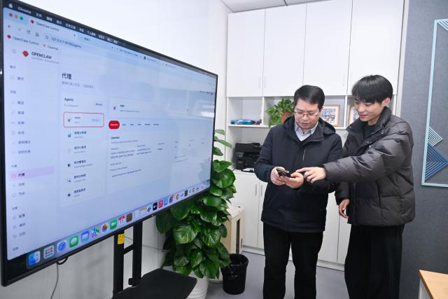 (260311) -- BEIJING, March 11, 2026 (Xinhua) -- A technician (R) communicates with a user after the installation of the open-source AI agent OpenClaw in Nanjing, east China's Jiangsu Province, March 11, 2026. "Raising lobster" and one-person companies (OPCs), which have sparked heated discussions in China's AI community and among the public, are also hot topics at the country's ongoing "two sessions" this year.
   The term "raising lobster" originated from the open-source AI agent OpenClaw, which uses a red lobster as its icon. It has since become a buzzword, adopted by Chinese users to describe the process of setting up and training this smart assistant. 
   TO GO WITH "Economic Watch: 'Claw-powered' one-person companies become hot topic at China's 'two sessions'" (Xinhua/Ji Chunpeng)