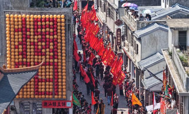 (260311) -- JIEYANG, March 11, 2026 (Xinhua) -- This aerial drone photo taken on March 11, 2026 shows a parade during the Chenghuang temple fair in Jieyang, south China's Guangdong Province. The Chenghuang temple fair, held on the 23rd day of the first month on the traditional Chinese calendar, is one of the major traditional folk cultural events in Jieyang. (Xinhua/Deng Hua)