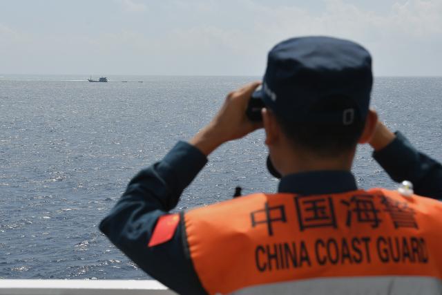(260311) -- SOUTH CHINA SEA, March 11, 2026 (Xinhua) -- A law enforcer watches out aboard the China Coast Guard (CCG) vessel Sandu in the South China Sea, March 6, 2026. The CCG vessel Sandu conducted patrols in the South China Sea to safeguard China's territorial sovereignty and maritime rights and interests. (Xinhua/Mao Jun)