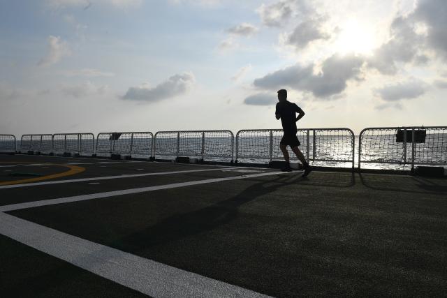 (260311) -- SOUTH CHINA SEA, March 11, 2026 (Xinhua) -- A law enforcer jogs aboard the China Coast Guard (CCG) vessel Sandu in the South China Sea, March 8, 2026. The CCG vessel Sandu conducted patrols in the South China Sea to safeguard China's territorial sovereignty and maritime rights and interests. (Xinhua/Mao Jun)