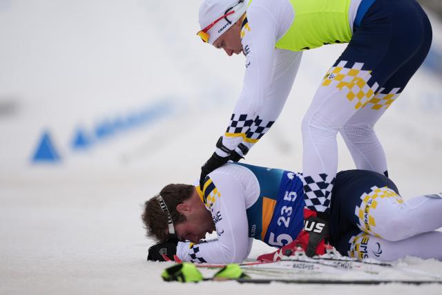 (260311) -- TESERO, March 11, 2026 (Xinhua) -- Zebastian Modin (Bottom) of Sweden is helped up by his guider Emli Talsi after the men's 10km interval start classic Vision Impaired of Para Cross-Country Skiing at the Milan-Cortina 2026 Paralympic Winter Games in Tesero, Italy, March 11, 2026. (Xinhua/Lian Zhen)