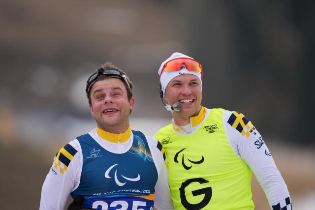 (260311) -- TESERO, March 11, 2026 (Xinhua) -- Zebastian Modin (L) of Sweden celebrates with his guider Emli Talsi after the men's 10km interval start classic Vision Impaired of Para Cross-Country Skiing at the Milan-Cortina 2026 Paralympic Winter Games in Tesero, Italy, March 11, 2026. (Xinhua/Lian Zhen)