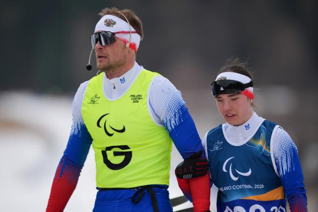(260311) -- TESERO, March 11, 2026 (Xinhua) -- Anastasiia Bagiian (R) of Russia and her guider Sergei Siniakin react during the women's 10km interval start classic Vision Impaired of Para Cross-Country Skiing at the Milan-Cortina 2026 Paralympic Winter Games in Tesero, Italy, March 11, 2026. (Xinhua/Lian Zhen)