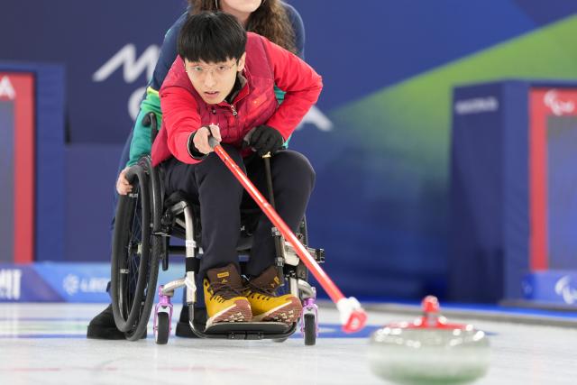 (260312) -- CORTINA D'AMPEZZO, March 12, 2026 (Xinhua) -- Yang Jinqiao of China competes during the wheelchair curling mixed doubles gold medal game between China and South Korea at the Milan-Cortina 2026 Paralympic Winter Games in Cortina D'ampezzo, Italy, March 11, 2026. (Xinhua/Lian Yi)