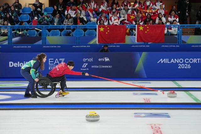 (260312) -- CORTINA D'AMPEZZO, March 12, 2026 (Xinhua) -- Yang Jinqiao of China competes during the wheelchair curling mixed doubles gold medal game between China and South Korea at the Milan-Cortina 2026 Paralympic Winter Games in Cortina D'ampezzo, Italy, March 11, 2026. (Xinhua/Mu Yu)