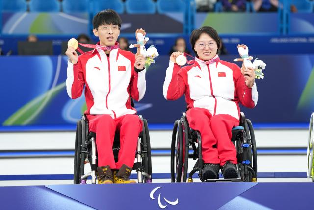 (260312) -- CORTINA D'AMPEZZO, March 12, 2026 (Xinhua) -- Gold medalists Yang Jinqiao (L)/Wang Meng of China pose during the awarding ceremony for the wheelchair curling mixed doubles event at the Milan-Cortina 2026 Paralympic Winter Games in Cortina D'ampezzo, Italy, March 11, 2026. (Xinhua/Lian Yi)