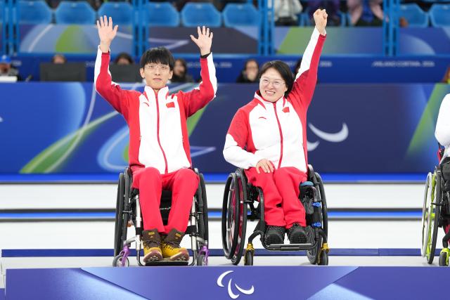 (260312) -- CORTINA D'AMPEZZO, March 12, 2026 (Xinhua) -- Gold medalists Yang Jinqiao (L)/Wang Meng of China pose during the awarding ceremony for the wheelchair curling mixed doubles event at the Milan-Cortina 2026 Paralympic Winter Games in Cortina D'ampezzo, Italy, March 11, 2026. (Xinhua/Lian Yi)