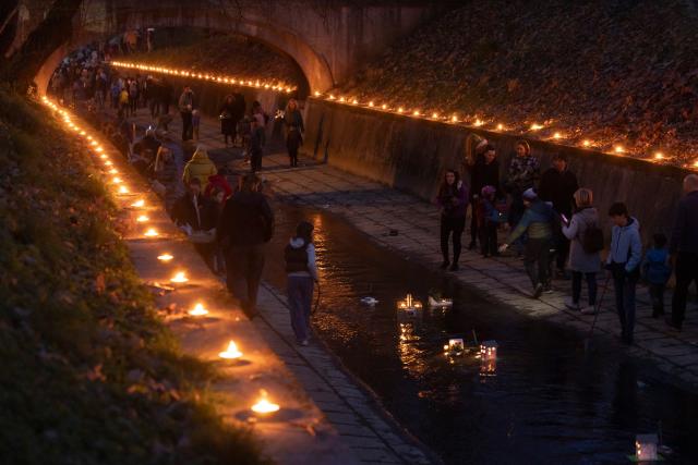 (260312) -- LJUBLJANA, March 12, 2026 (Xinhua) -- People watch their floats going down a stream to celebrate the arrival of spring in Ljubljana, Slovenia, March 11, 2026. According to the Slovenian old calendar, March 12 marks the start of spring. It is a local tradition to send off floats downstream on March 11 to celebrate spring's arrival. (Photo by Zeljko Stevanic/Xinhua)
