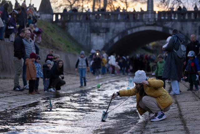 (260312) -- LJUBLJANA, March 12, 2026 (Xinhua) -- A girl releases a float on a stream to celebrate the arrival of spring in Ljubljana, Slovenia, March 11, 2026. According to the Slovenian old calendar, March 12 marks the start of spring. It is a local tradition to send off floats downstream on March 11 to celebrate spring's arrival. (Photo by Zeljko Stevanic/Xinhua)