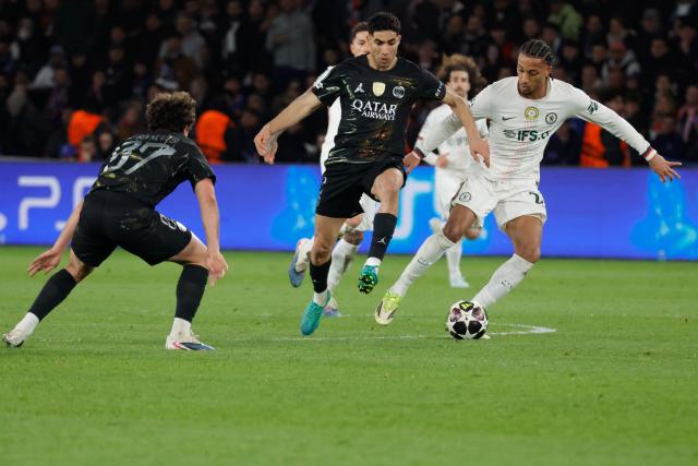 (260312) -- PARIS, March 12, 2026 (Xinhua) -- Achraf Hakimi (C) of Paris Saint-Germain vies with Joao Pedro (R) of Chelsea during the UEFA Champions League round of 16 first leg match between Paris Saint-Germain (PSG) and Chelsea in Paris, France, March 11, 2026. (Photo by Henri Szwarc/Xinhua)