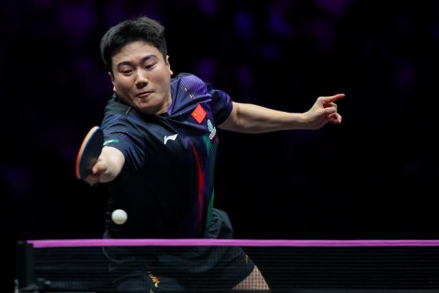 (260312) -- CHONGQING, March 12, 2026 (Xinhua) -- Liang Jingkun hits a return during the men's singles round of 32 match between Liang Jingkun of China and Xiang Peng of China at the WTT Champions Chongqing 2026 in southwest China's Chongqing, March 12, 2026. (Xinhua/Huang Wei)
