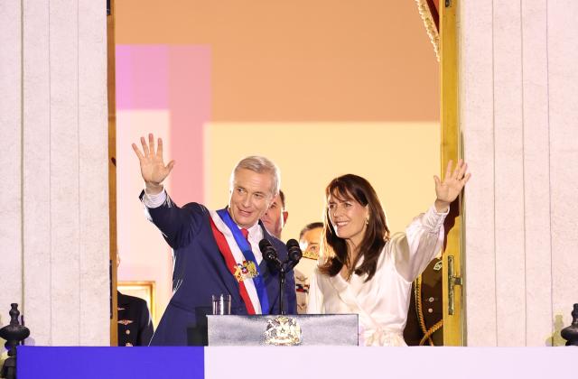 (260312) -- SANTIAGO, March 12, 2026 (Xinhua) -- Chile's President Jose Antonio Kast and his wife Maria Pia Adriasola wave to the crowd at the La Moneda Presidential Palace in Santiago, Chile, March 11, 2026.
  Kast took office on Wednesday as Chile's new president for the 2026-2030 term, succeeding Gabriel Boric. (Xinhua/Zhou Jiayi)