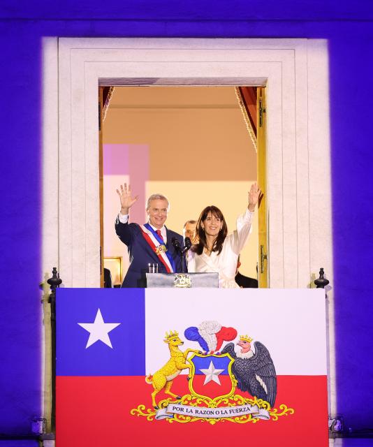 (260312) -- SANTIAGO, March 12, 2026 (Xinhua) -- Chile's President Jose Antonio Kast and his wife Maria Pia Adriasola wave to the crowd at the La Moneda Presidential Palace in Santiago, Chile, March 11, 2026.
  Kast took office on Wednesday as Chile's new president for the 2026-2030 term, succeeding Gabriel Boric. (Xinhua/Zhou Jiayi)