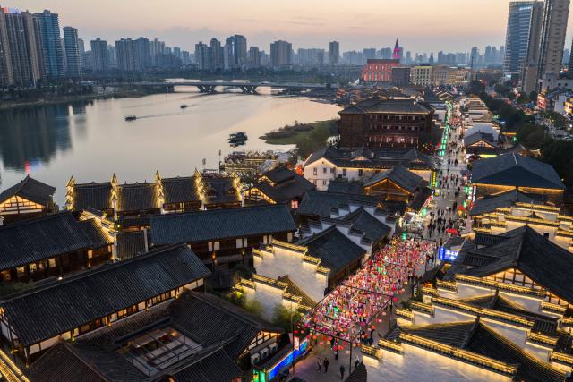 (260312) -- CHANGSHA, March 12, 2026 (Xinhua) -- An aerial drone photo shows people visiting Changde Hejie along the Chuanzi River in Changde, central China's Hunan Province, March 11, 2026.
  The once heavily polluted Chuanzi River, which meanders through the city proper of Changde, has now become a clean and attractive scenic spot along its banks. Boasting a long history, the riverside Changde Hejie old street has been transformed into a historical and cultural block. (Xinhua/Chen Sihan)