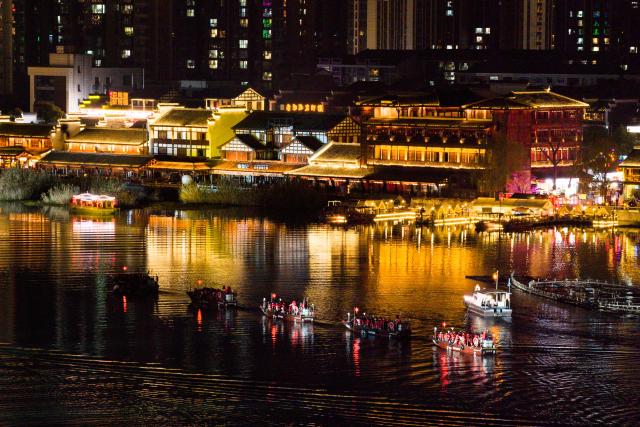 (260312) -- CHANGSHA, March 12, 2026 (Xinhua) -- An aerial drone photo shows people touring along the Chuanzi River in Changde, central China's Hunan Province, March 11, 2026.
  The once heavily polluted Chuanzi River, which meanders through the city proper of Changde, has now become a clean and attractive scenic spot along its banks. Boasting a long history, the riverside Changde Hejie old street has been transformed into a historical and cultural block. (Xinhua/Chen Sihan)