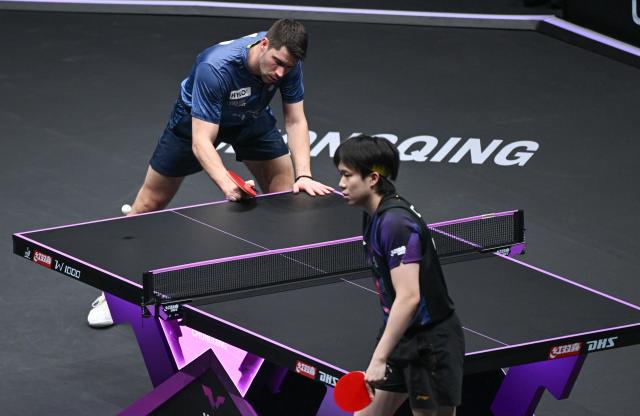 (260312) -- CHONGQING, March 12, 2026 (Xinhua) -- Patrick Franziska (L) of Germany reacts during the men's singles round of 16 match against Wang Chuqin of China at the WTT Champions Chongqing 2026 in southwest China's Chongqing, March 12, 2026. (Xinhua/Chen Cheng)