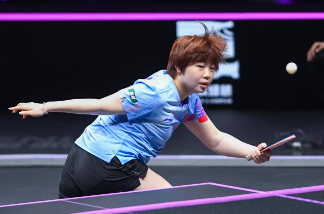 (260312) -- CHONGQING, March 12, 2026 (Xinhua) -- Kuai Man of China hits a return during the women's singles round of 16 match against Bruna Takahashi of Brazil at the WTT Champions Chongqing 2026 in southwest China's Chongqing, March 12, 2026. (Xinhua/Tang Yi)
